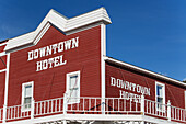 Das rote und weiße Gebäude eines Hotels in der Innenstadt vor einem strahlend blauen Himmel; Dawson City, Yukon, Kanada