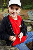 Junge schnitzt einen Stock mit seinem ersten Taschenmesser, Algonquin Park, Ontario, Kanada