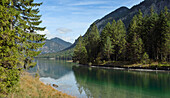Landschaftlicher Blick auf Berge und einen klaren See (Plansee) im Herbst, Tirol, Österreich