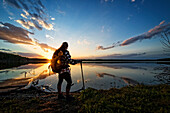 Hiker by Calm Lake at Sunset, Saskatchewan, Canada