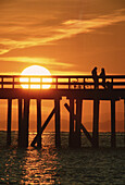 Menschen am Pier bei Sonnenuntergang, White Rock, BC, Kanada