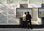 Männer schauen auf eine Informationstafel Shanghai, China