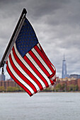 Amerikanische Flagge mit der Skyline von New York City und dem East River im Hintergrund, New York, USA