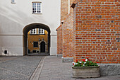 Pflanzgefäß an einer Backsteinmauer und Durchgang durch ein Gebäude, Stare Miasto, Warschau, Polen