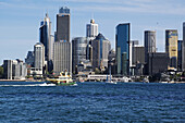 Ferry boat approaching teminal at  Circular Quay and skyline of Sydney, Australia