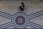 Person walking on the mosaic tiled floor in the Queen Victoria Building in the Central Business District of Sydney, Australia