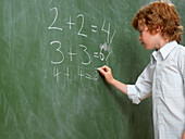 Boy Writing on Blackboard