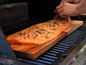 Man Preparing Fish on Grill