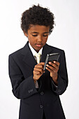 Kleiner Junge als Geschäftsmann verkleidet benutzt Handy