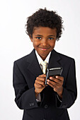 Kleiner Junge als Geschäftsmann verkleidet mit Handy