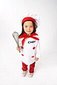 Little Girl Dressed Up as a Chef Holding a Whisk