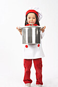 Kleines Mädchen als Koch verkleidet, einen Topf haltend