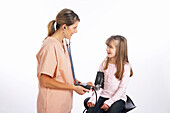 Krankenschwester prüft Blutdruck eines Mädchens