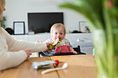 Toddler with down syndrome sitting at table