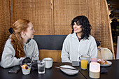 Junge Frauen sitzen im Cafe und unterhalten sich