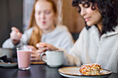 Frauen essen und trinken Kaffee im Cafe