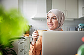 Lächelnde Frau mit Hidschab bei einem Kaffee