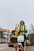 Female road worker operating machinery