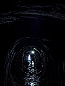 Silhouette einer in einer Höhle stehenden Person