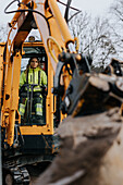 Female road worker operating excavator
