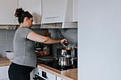 Pregnant woman in kitchen preparing food