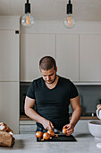 Mann in Küche bei der Essenszubereitung