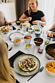 Gruppe von Freunden beim mexikanischen Essen zu Hause