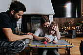 Eltern spielen mit behindertem Kind im Wohnzimmer