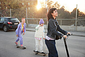 Junge Frau und Junge fahren zusammen Skateboard