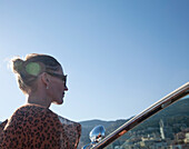 Frau mit Sonnenbrille schaut beim Bootfahren nach vorne, Objektivflair