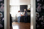 Rear view of mature couple standing in kitchen