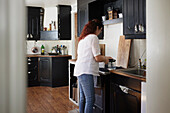 Mature woman holding jug in kitchen