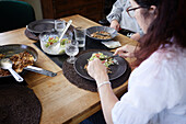 Frau beim Essen am Esstisch aus hohem Winkel gesehen