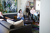 Eltern mit behinderter Tochter im Rollstuhl entspannen sich im Wohnzimmer