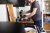 Mann in der Küche wäscht Geschirr an der Spüle