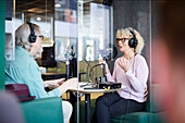 Älterer Mann und Frau unterhalten sich in einer Radiosendung oder einem Podcast
