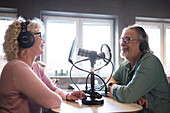 Reifer Mann und Frau im Gespräch in einer Radiosendung oder einem Podcast