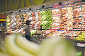 Blick auf ein Paar, das im Supermarkt steht und sich beim Aussuchen von Äpfeln unterhält