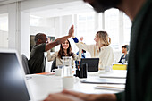 Group of business people high-five during business meeting in office
