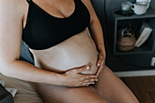 Close-up of pregnant woman touching belly