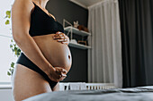 Nahaufnahme einer schwangeren Frau, die ihren Bauch berührt