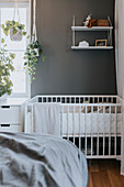 Baby crib in corner of bedroom