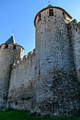 The medieval city of Carcassonne, towers with pointed roofs and solid walls of the fortified buildings, a low angle view. 