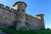 The medieval city of Carcassonne, towers with pointed roofs and solid walls of the fortified buildings, a low angle view. 