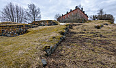 Eine historische Stätte, ein Gebäude und eine archäologische Stätte, die Inselfestung von Suomenlinna, Mauern und Gräben der Festung und ein Gebäude.