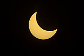 Die partielle Sonnenfinsternis, 23. Oktober 2014, von Jasper, Alberta aus gesehen, aufgenommen bei klarem Himmel durch einen Mylar-Filter auf der Vorderseite eines 66mm f/6 apo Refraktors mit der Canon 60Da für 1/8000 (!) s Belichtung bei ISO 100. Die Farben sind natürlich, und der Mylar-Filter sorgt für ein neutrales Weißlichtbild. Der große Sonnenfleck, der sich an diesem Tag auf der Sonne befand, verschwindet gerade hinter dem Mondrand. Der Mylar-Filter ergab eine weiße Sonne, ihre natürliche Farbe, aber ich habe das Sonnenscheibchen gelb eingefärbt, um ein angenehmeres Bild zu erhalten, da