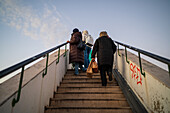 People climbing stairs to road bridge in Belem, Lisbon, Portugal