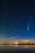 Comet NEOWISE (C/2020 F3) over the still waters this night of Crawling Lake in southern Alberta. The Big Dipper is at top. Even in this short exposure, the two tails — dust and ion — are visible. This was July 20, 2020. The blue ion tail is extending up into the Bowl of the Big Dipper, for some 20° in length. Very impressive!