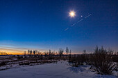 Ein belebter Morgenhimmel, mit der abnehmenden Mondsichel, die über dem Paar von Mars (links) und Jupiter (rechts) leuchtet, und der Raumstation, die ebenfalls in vier Belichtungen vorbeizieht. Der Mond und die Planeten stehen in Waage. Links von der Mitte gehen Antares und die Sterne des Skorpions gerade in der Morgendämmerung auf.