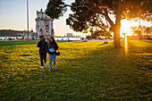 Menschen genießen den Garten des Belen-Turms (Jardim da Torre de Belem) bei Sonnenuntergang, Lissabon, Portugal